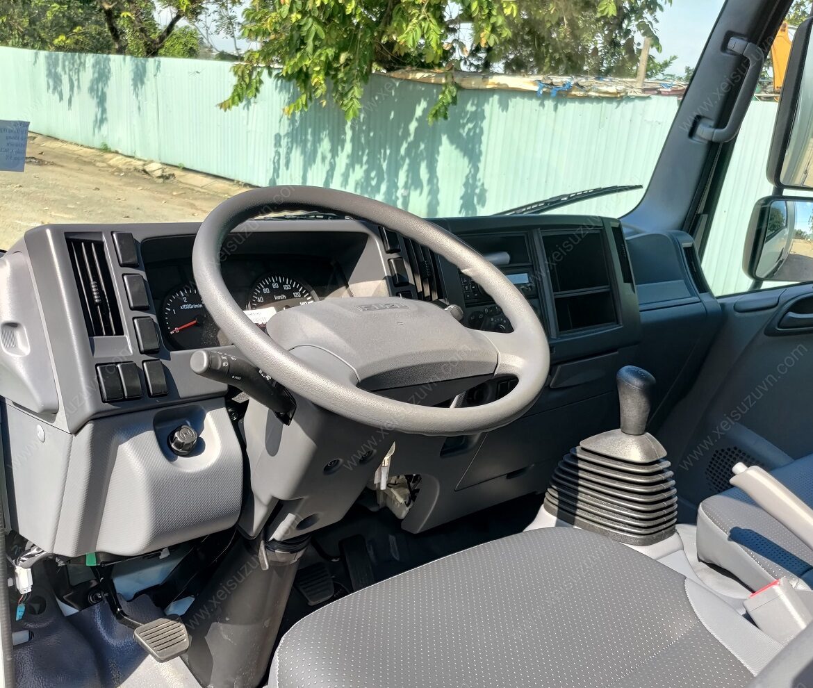 Nội thất xe tải Isuzu 1.9 tấn với ghế bọc nỉ, vô lăng truyền thống, bảng điều khiển rõ ràng.